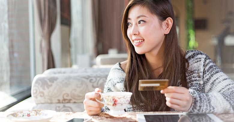 Young Chinese woman shopping online in a cafe